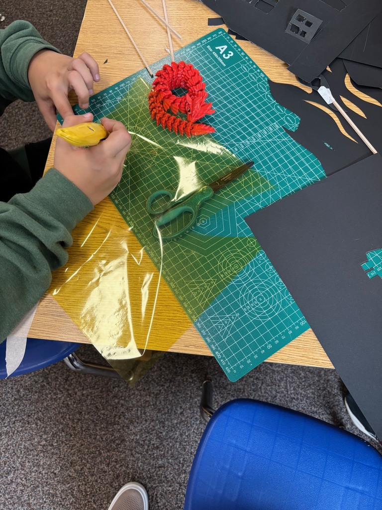 Students cutting materials to make shadows.