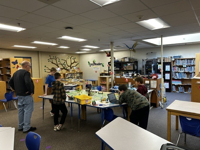 Students coding their robot with Mr. Phillips