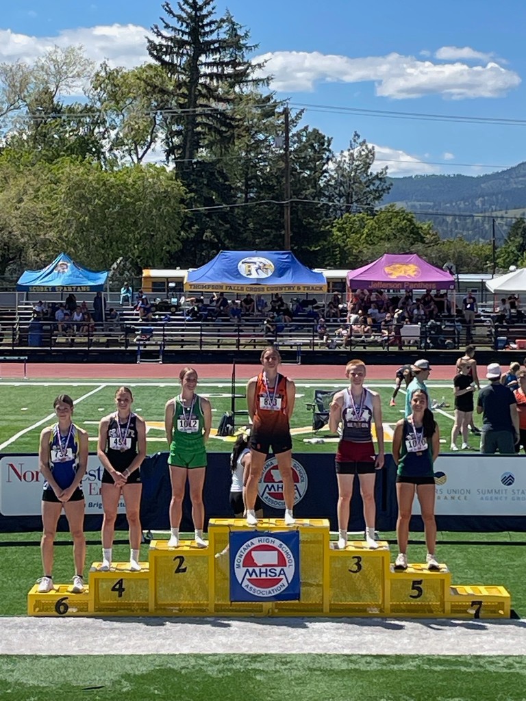 Savage Public School student Cambry placed 1st at state track podium, smiling at the camera.
