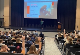 Students listen as the speaker discusses self-care tools for tough moments, shown on the presentation slide.