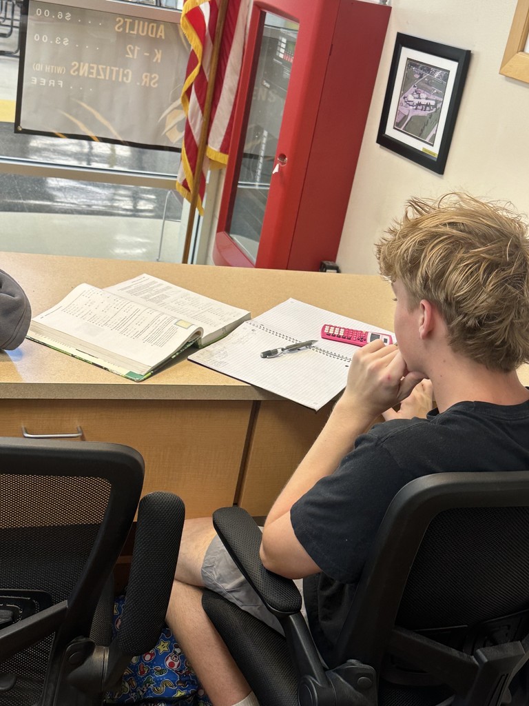 a high school student sits at a counter doing math homework 