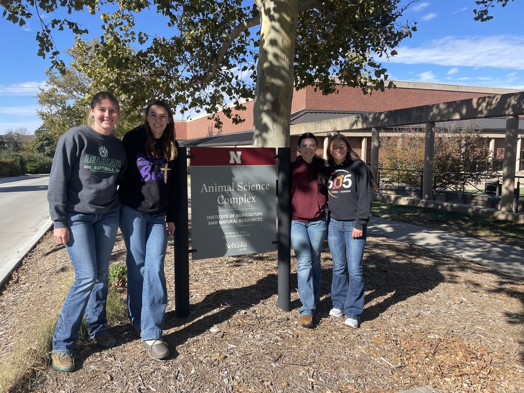 Four students stand outside the University of Nebraska, Lincoln Animal Science Complex sign. 