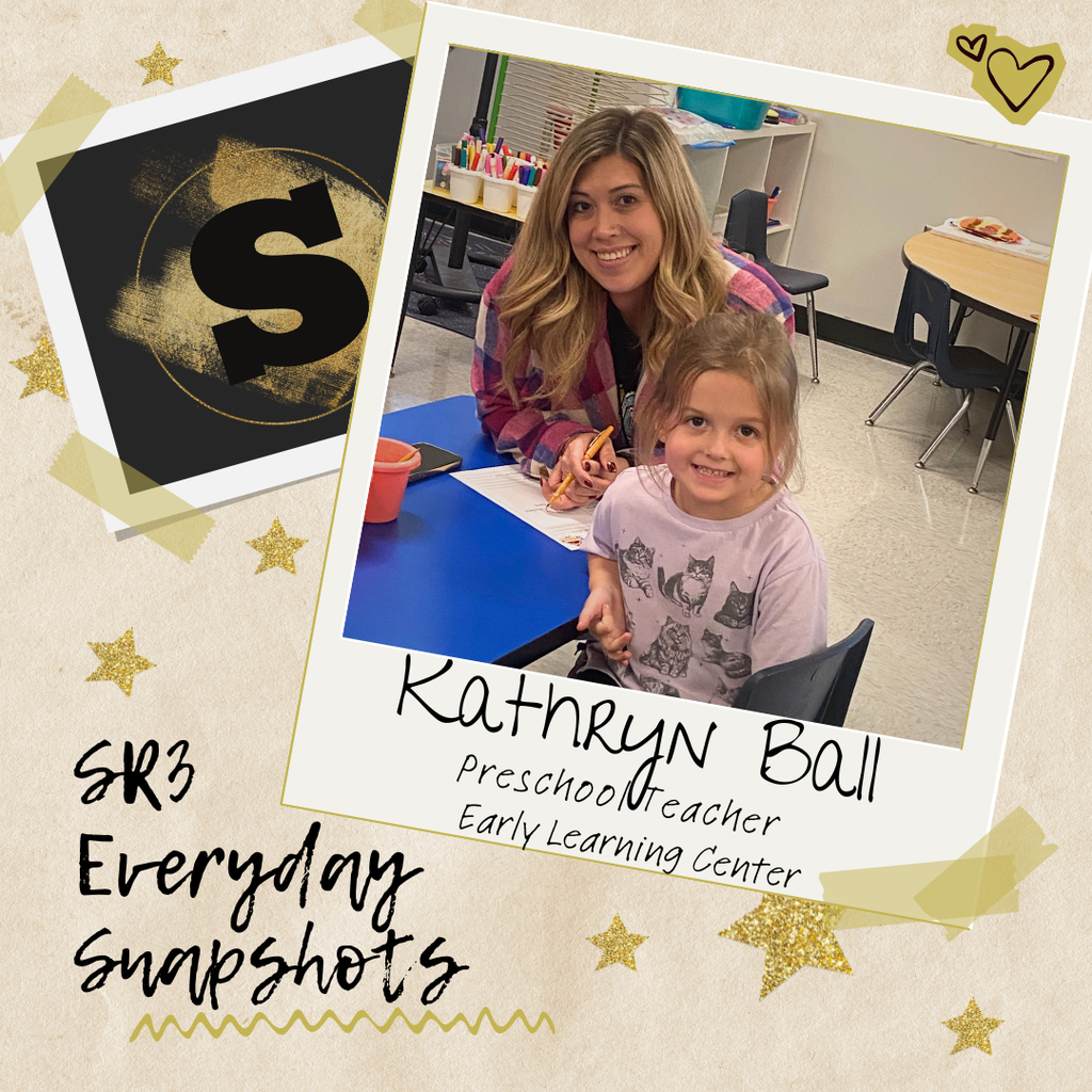 Preschool teacher Kathryn Ball sits at a small table with a young student, both smiling in a classroom at the Early Learning Center. 