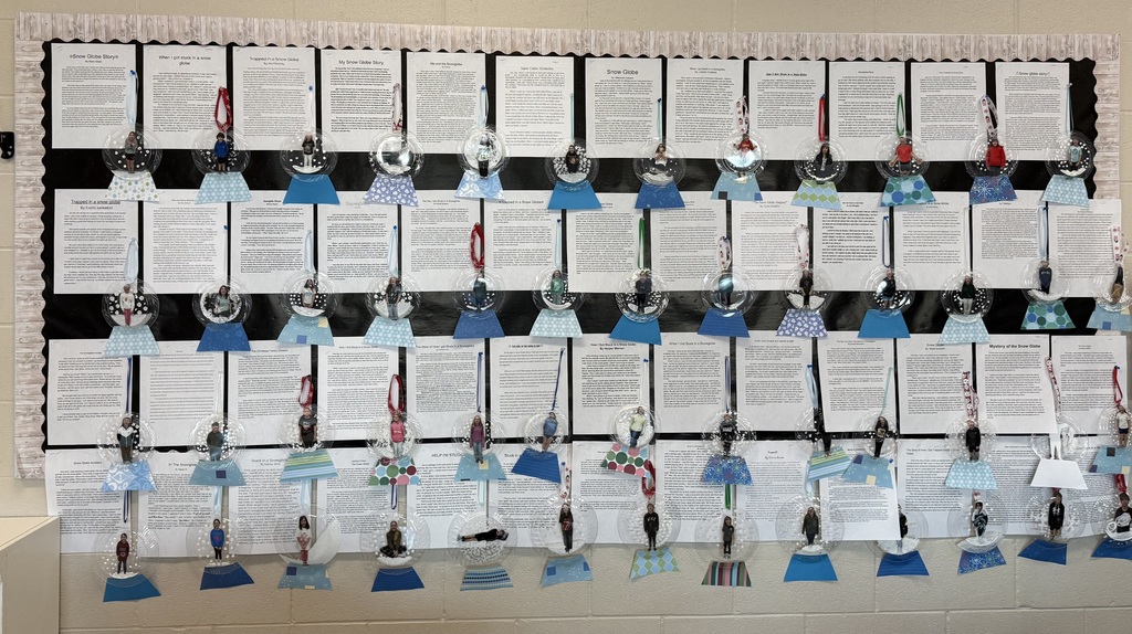 Hallway bulletin board displaying sixth-grade writing assignments about snow globes, with student photos placed inside clear plastic globe ornaments mounted on blue paper bases.