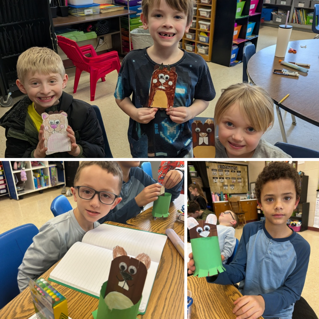 Elementary students smiling and posing with their completed groundhog crafts at classroom tables.