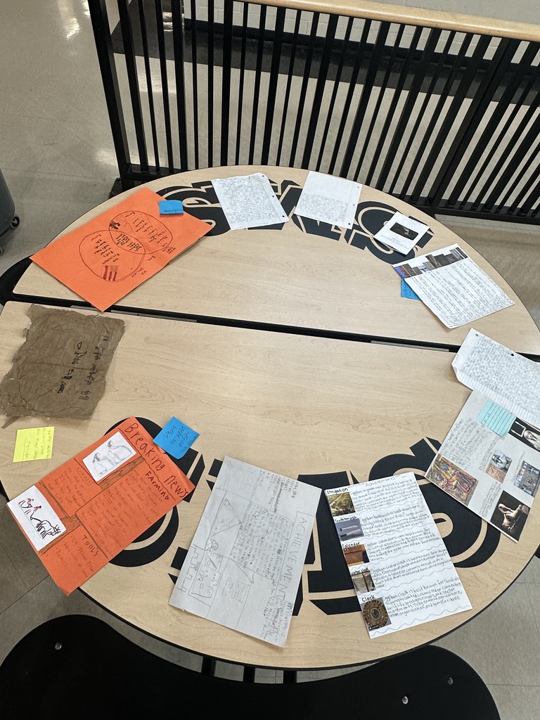 A table of handwritten research papers and illustrated projects about Egyptian history and culture.
