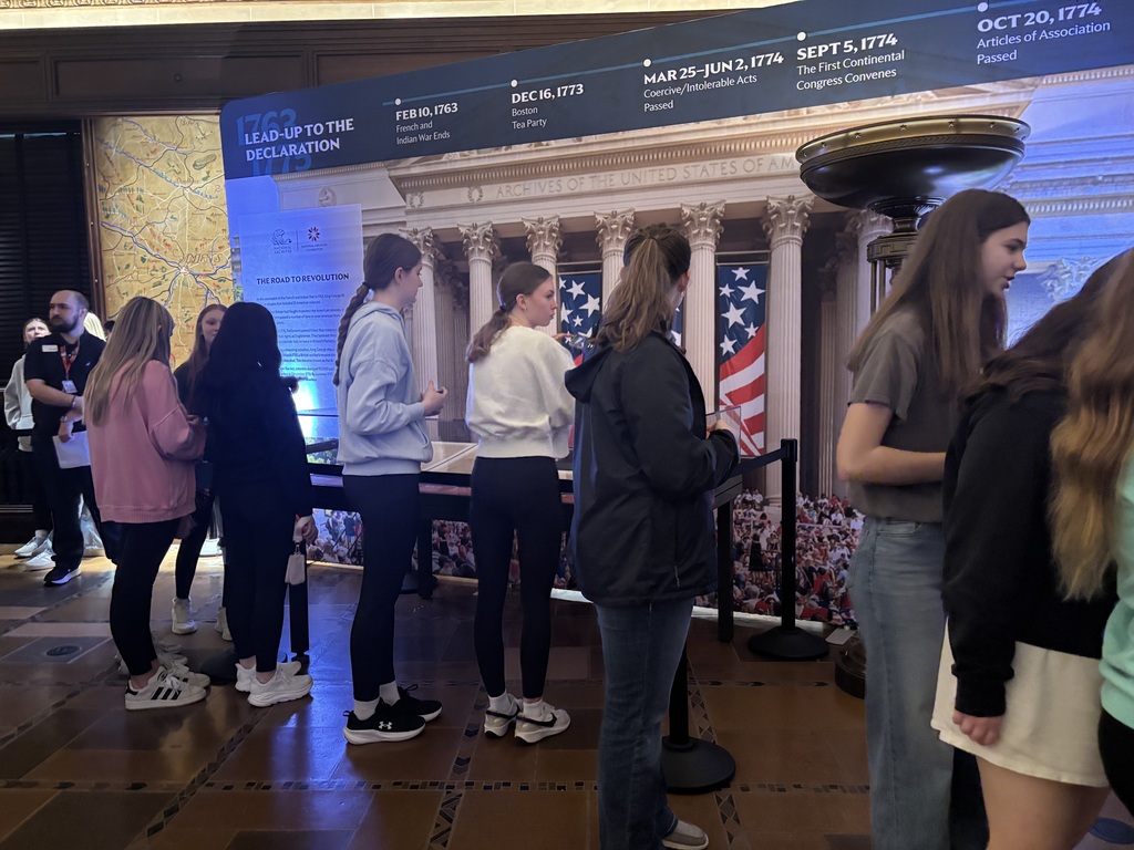 Students explore a “Lead-Up to the Declaration” exhibit featuring a timeline and historical display panels.