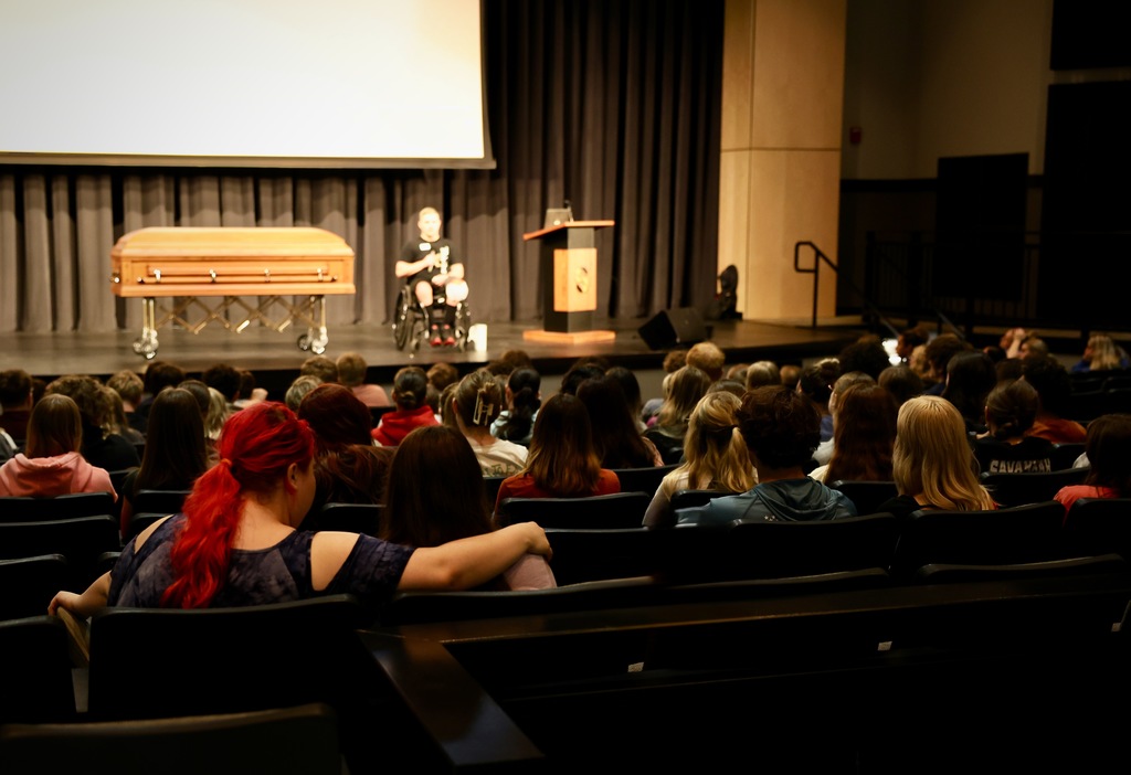 High school students seated in an auditorium watching a speaker during the Docudrama safety presentation.