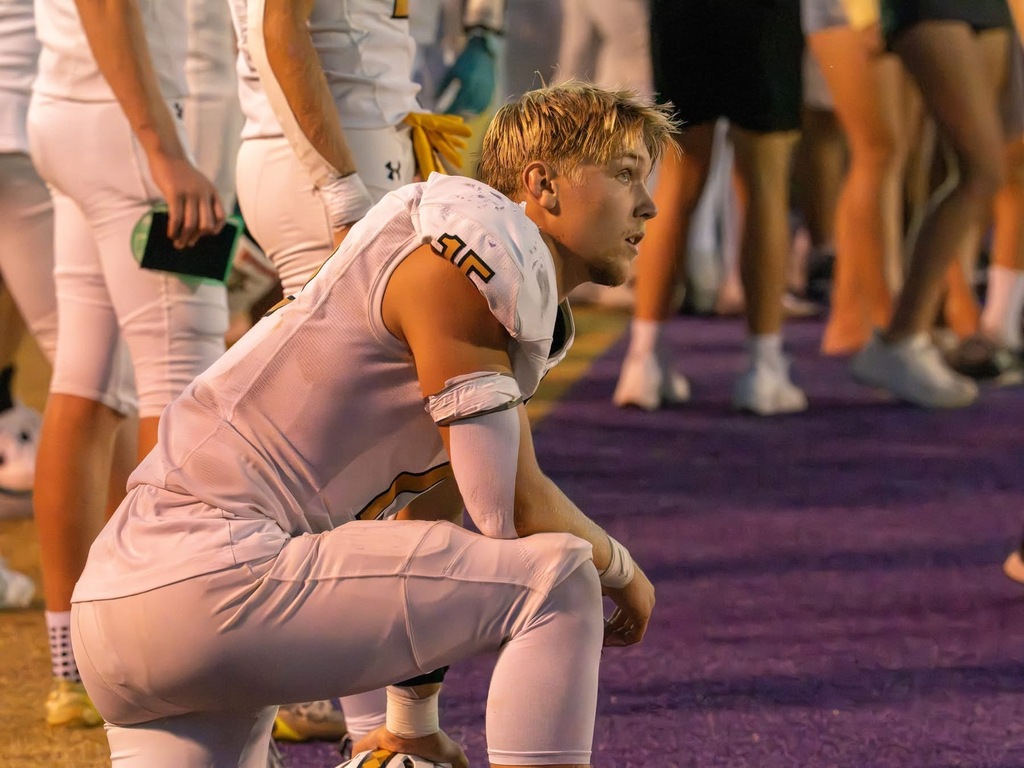 A Savannah football player kneels on the sideline, focused on the action during Friday night’s game.
