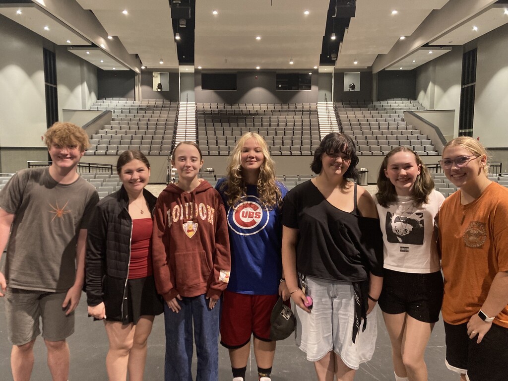 Seven Savannah High School choir students stand together on stage in the Performing Arts Center.