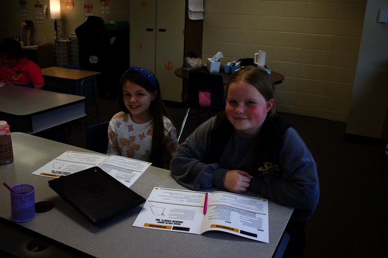 Two Amazonia Elementary fifth graders sit at desks with Junior Deputy program materials during class.