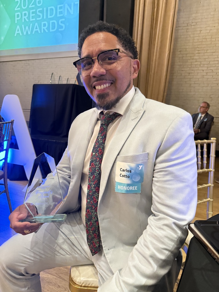Photo of Dr. Cotto holding YMCA award