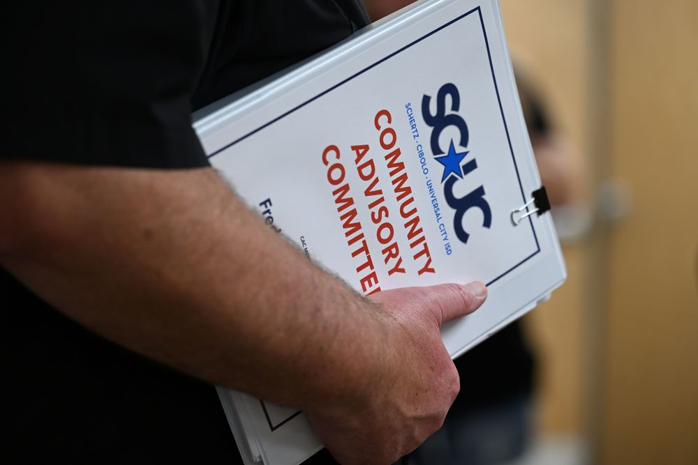 Community Advisory Committee binder held in the hand of a committee member