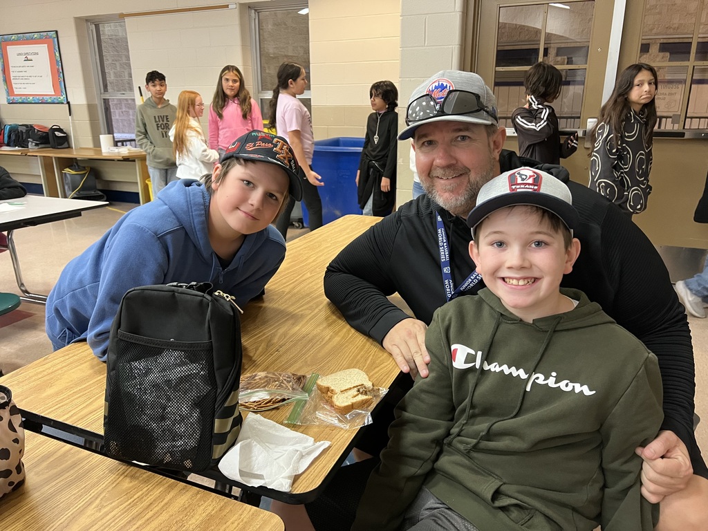 Coach Ryan, his son and his friend show off their hats during lunch.