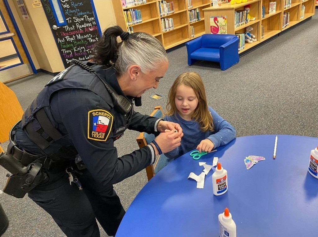 Police Officer helping student glue bookmark