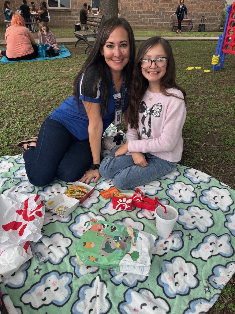 students and loved ones having a picnic style lunch at school.