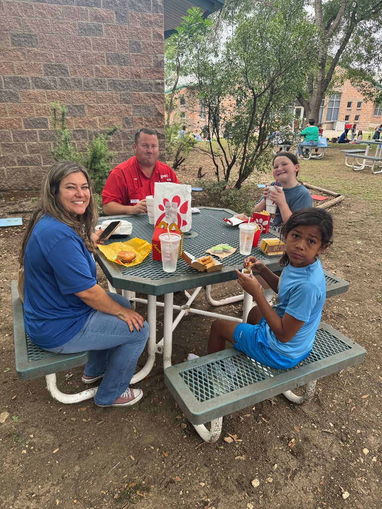 students and loved ones having a picnic style lunch at school.