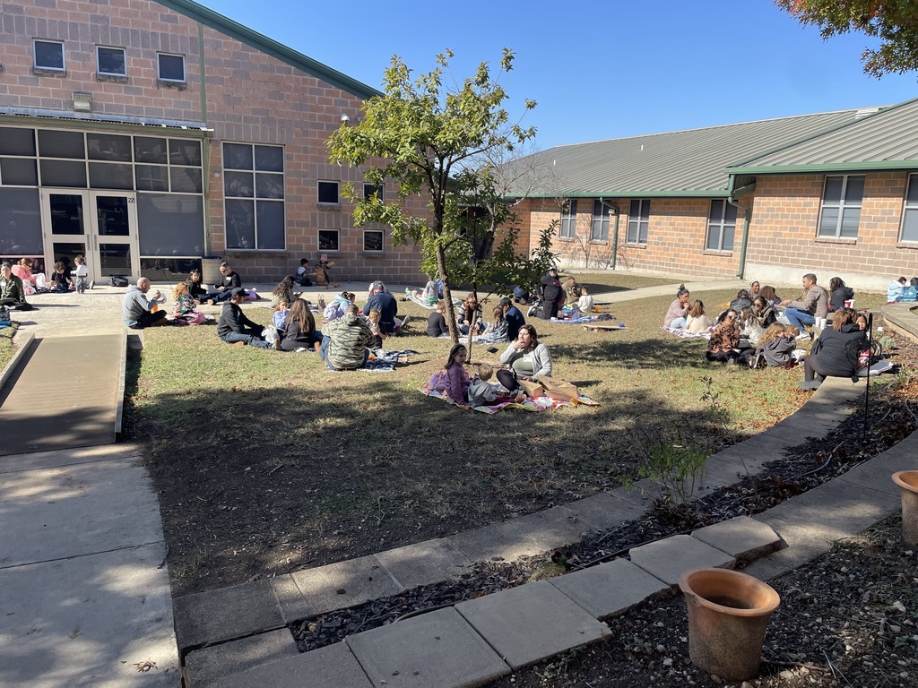 students and loved ones having a picnic style lunch at school.