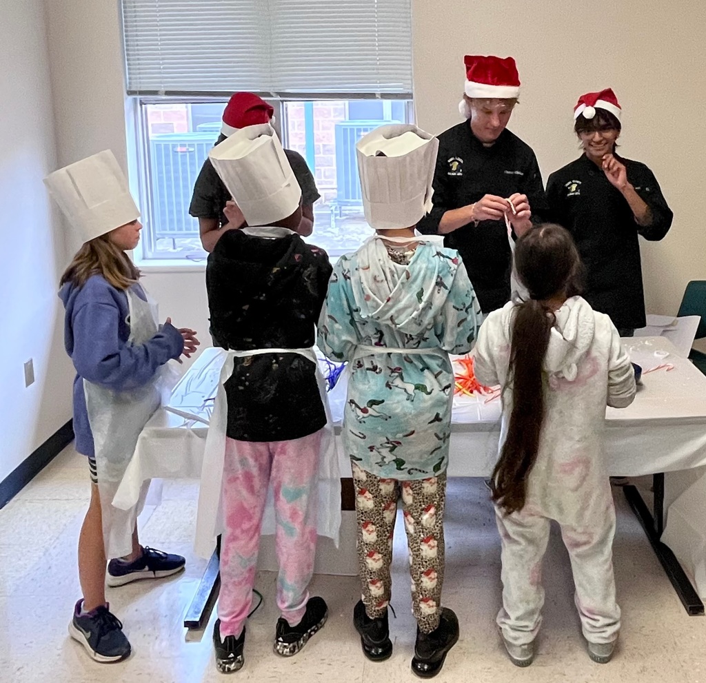 students cooking pancakes assisted by the high school culinary department.