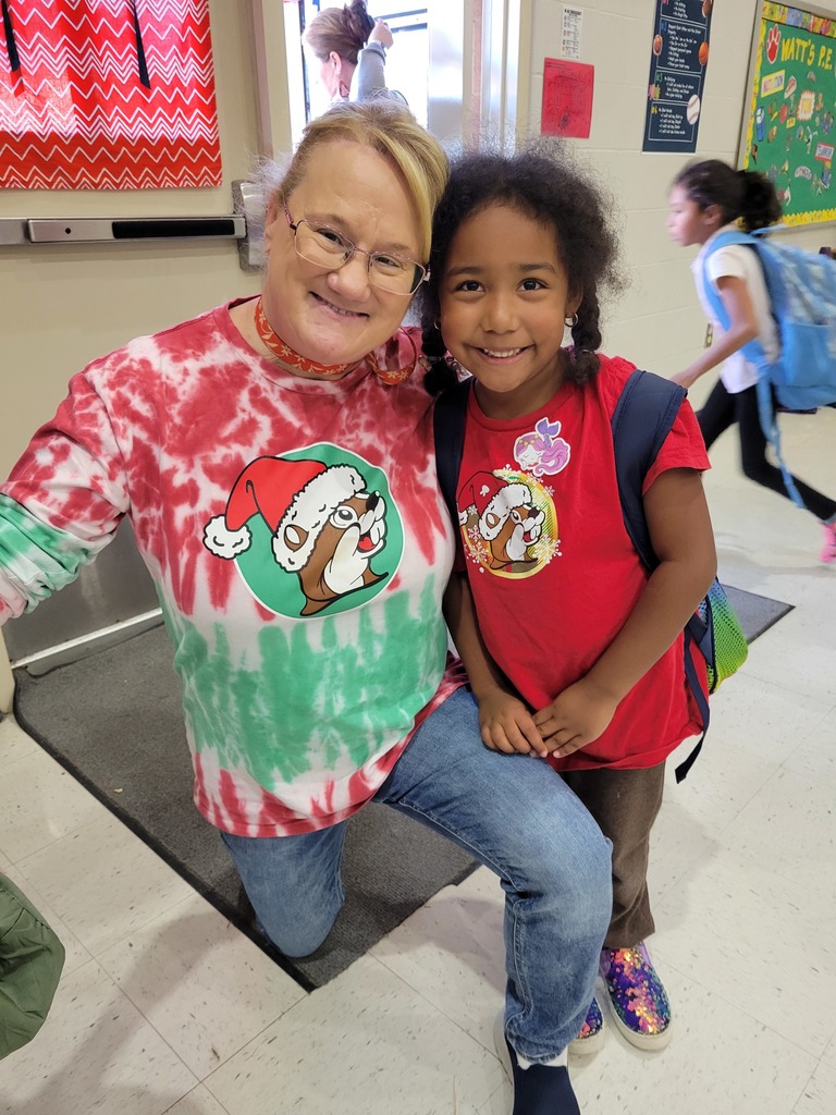 Pre-Kindergarten teacher and student wearing holiday shirts with matching cartoon type graphics.