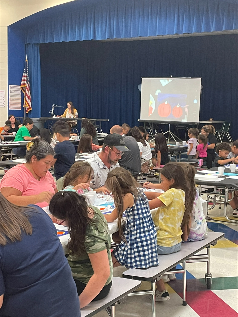 students and their families engaged in a family art night at their elementary school.