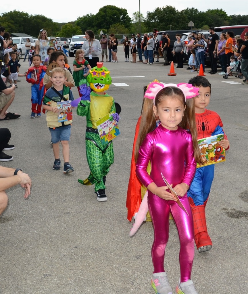 students holding their favorite storybook and dressed as their favorite book character. 