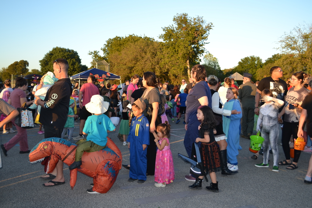 students dressed in their favorite storybook character with their parents attending their school's fall family event. 
