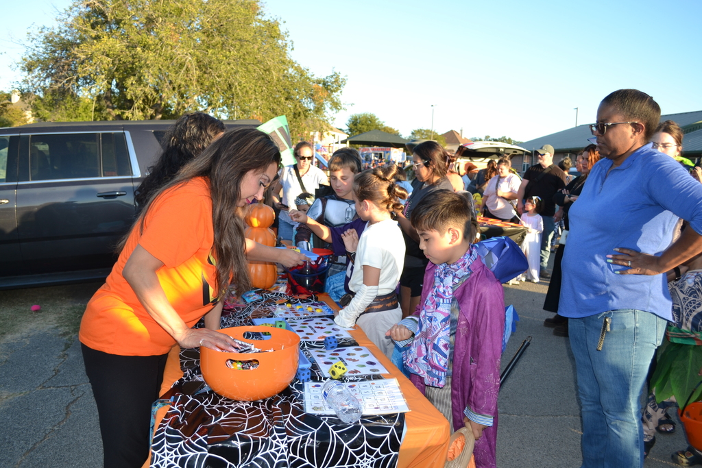 students dressed in their favorite storybook character with their parents attending their school's fall family event. 