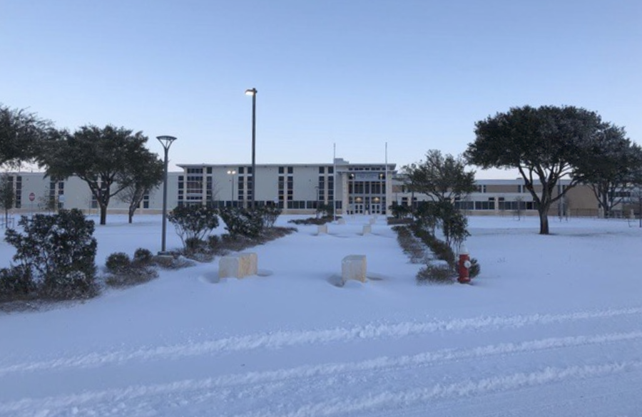 exterior of a high school beneath an early morning sky. snow covers the grounds of the school.