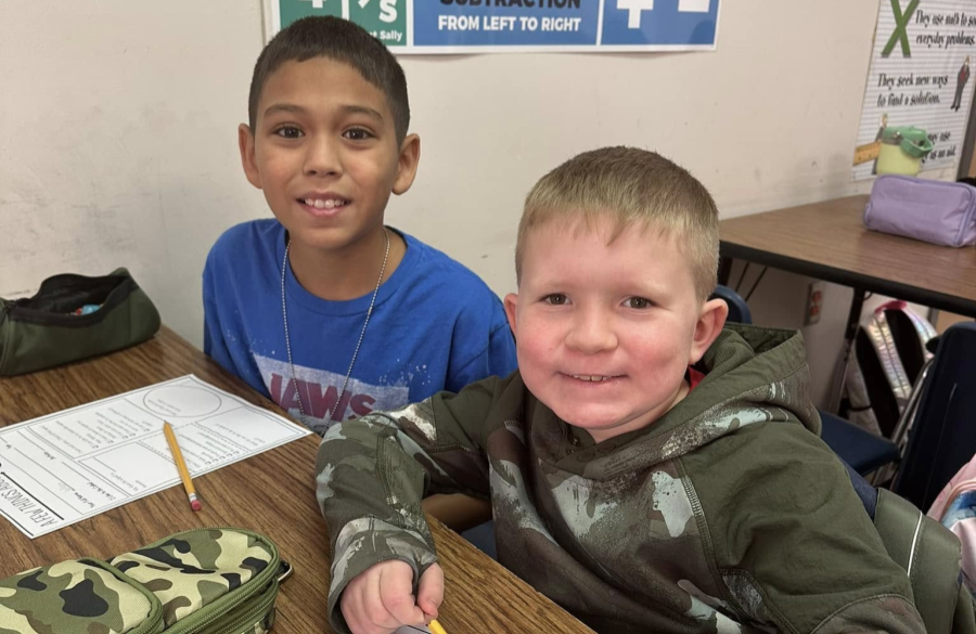 two students posing together in a classroom