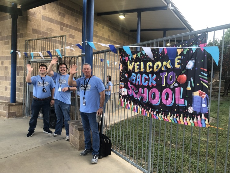 students being greeted by teachers on their way into school