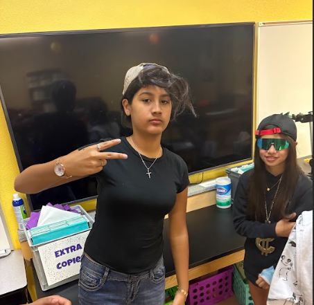 6th grade gir wearing hat and giving a peace sign