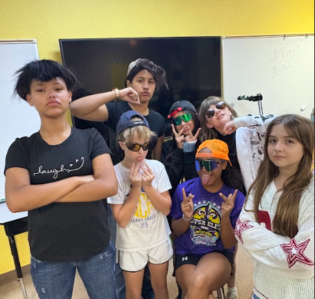 6th grade students posing with hats in class