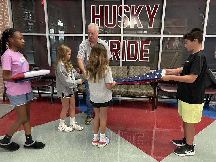 students folding American flag