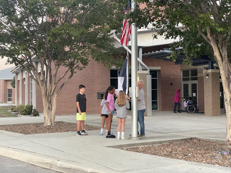 students hanging up the American flag