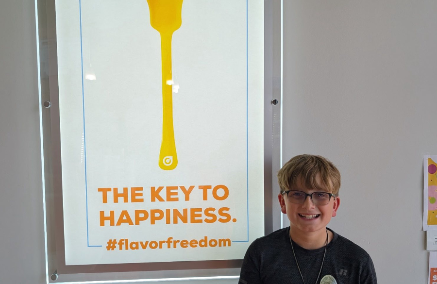 Wilder student next to an orange leaf sign.