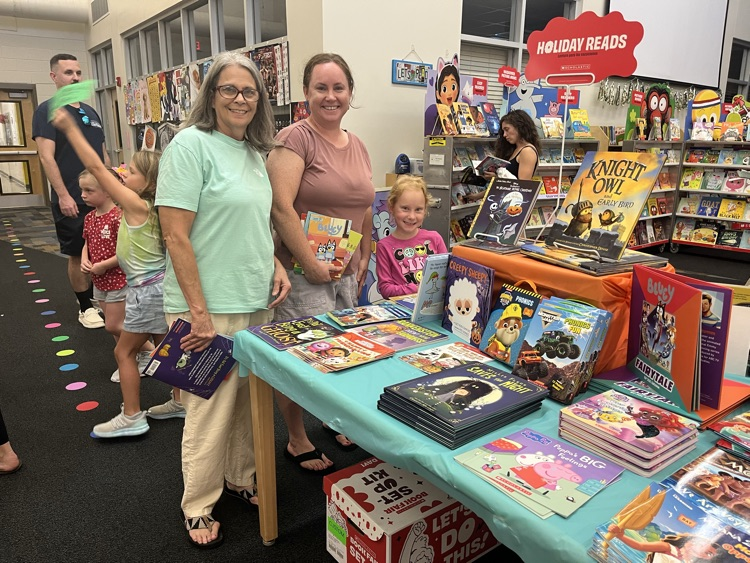 two adults and one child enjoying the book fair.