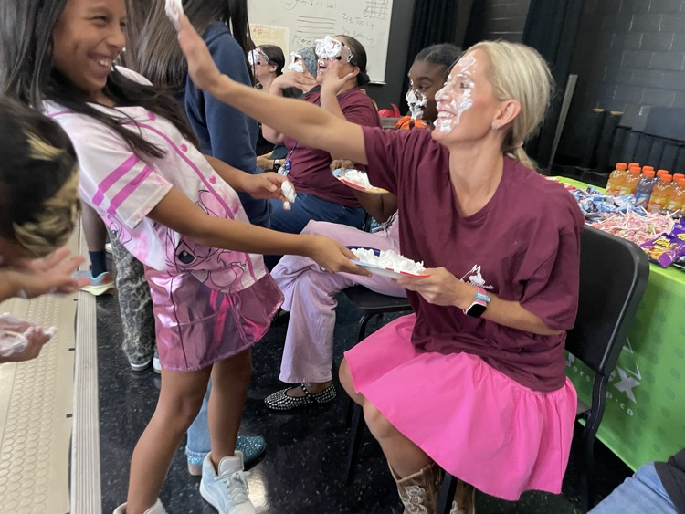 miss Housley, putting pie on the student face