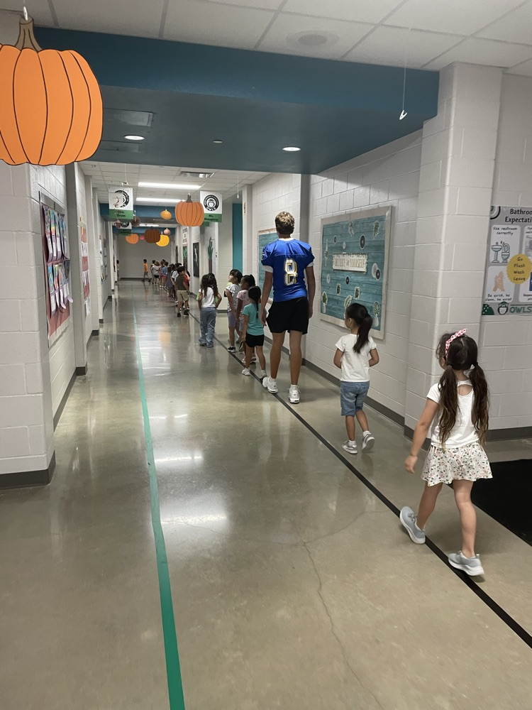 Buff helping students down the hallway 