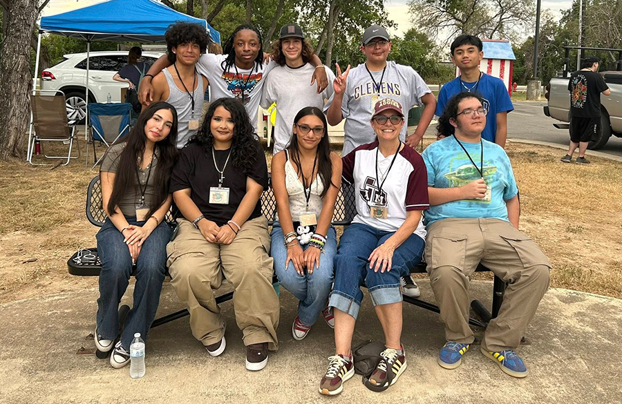high school students & their teacher relax at an outdoor bench after volunteering at an area food pantry