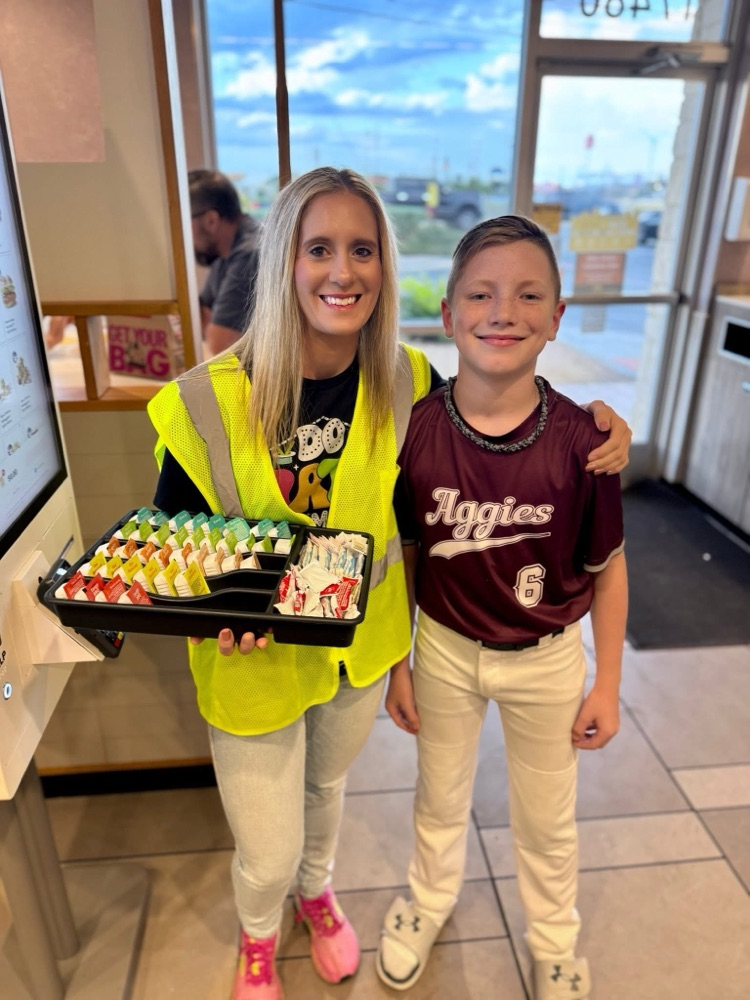 Miss Housley giving cookies to a student wearing baseball gear