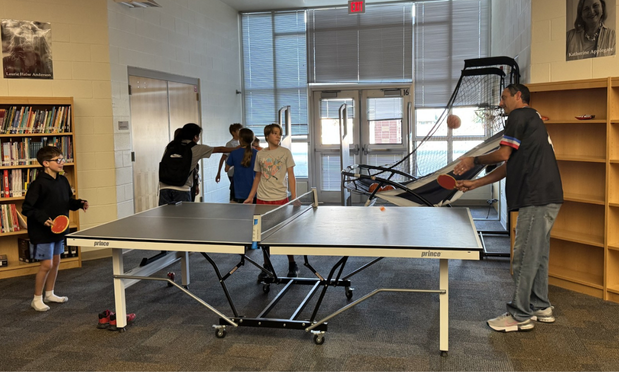 Mr. Morrison and a group of students playing ping pong at Game Central