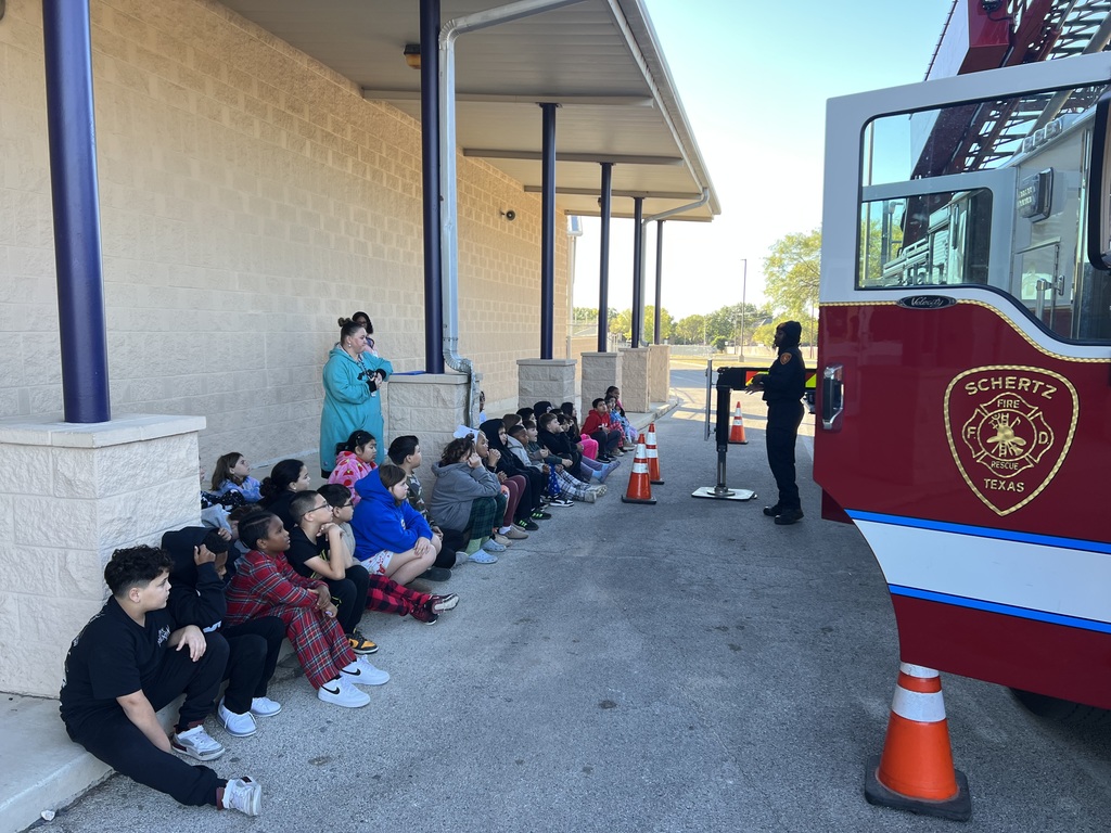 students listening to a firefighter
