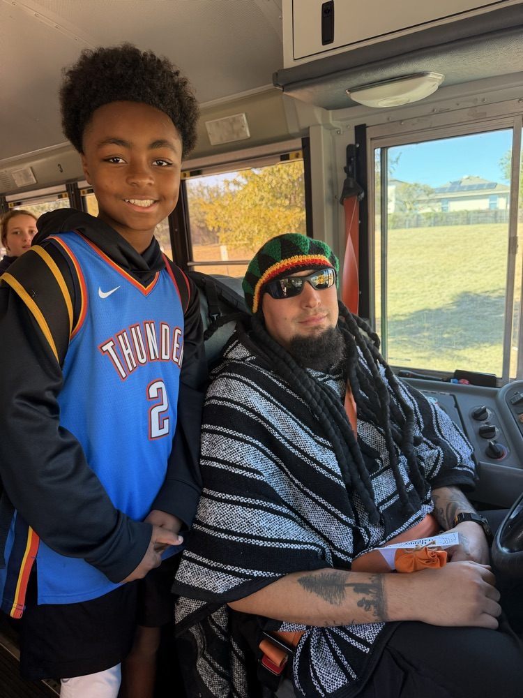 Student in basketball costume posing with Bus Driver in a poncho costume