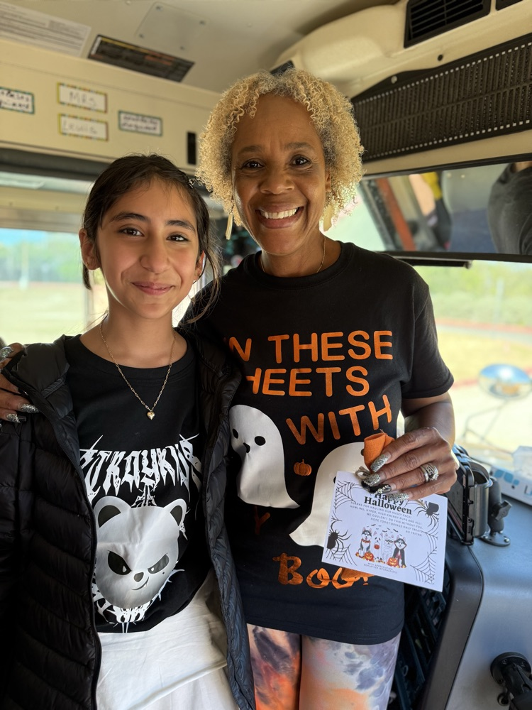 Student posing with Bus Driver and gift