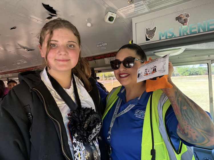 A student posing with a Bus Driver holding a gift