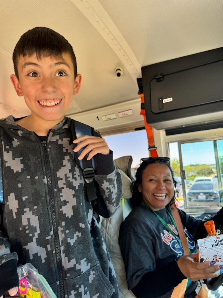 A student posing with a Bus Driver holding a gift