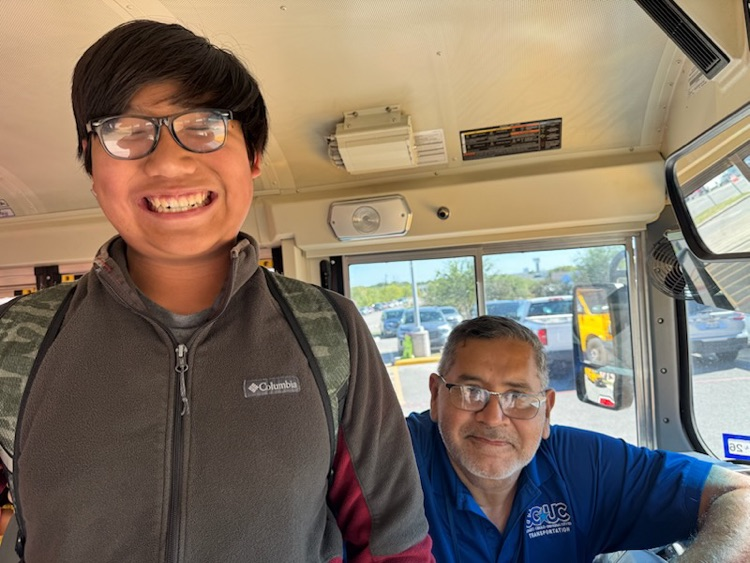 A boy standing next to a Bus Driver
