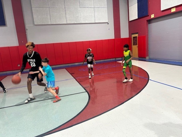 More Students playing basketball with a high schooler