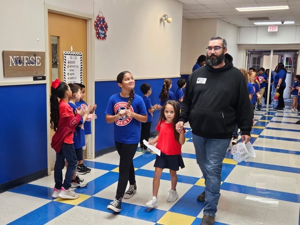 Watts ES student beams at her father during the school's Veterans Day parade